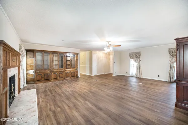 an empty room with a window and a fan