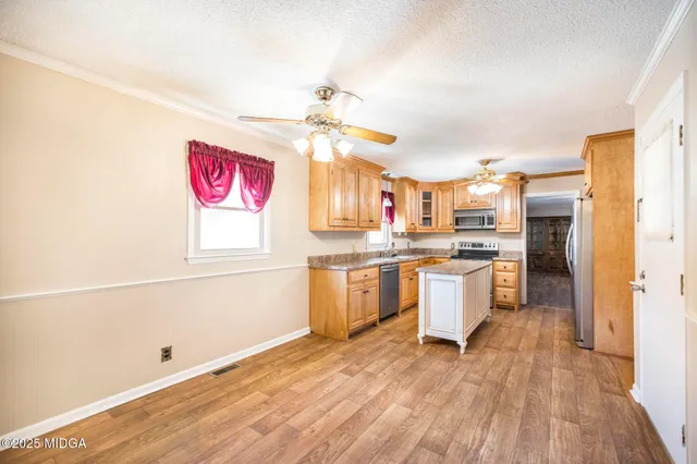 a kitchen with a refrigerator cabinets and wooden floor