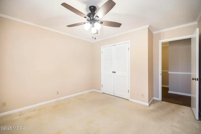 an empty room with a ceiling fan and a window