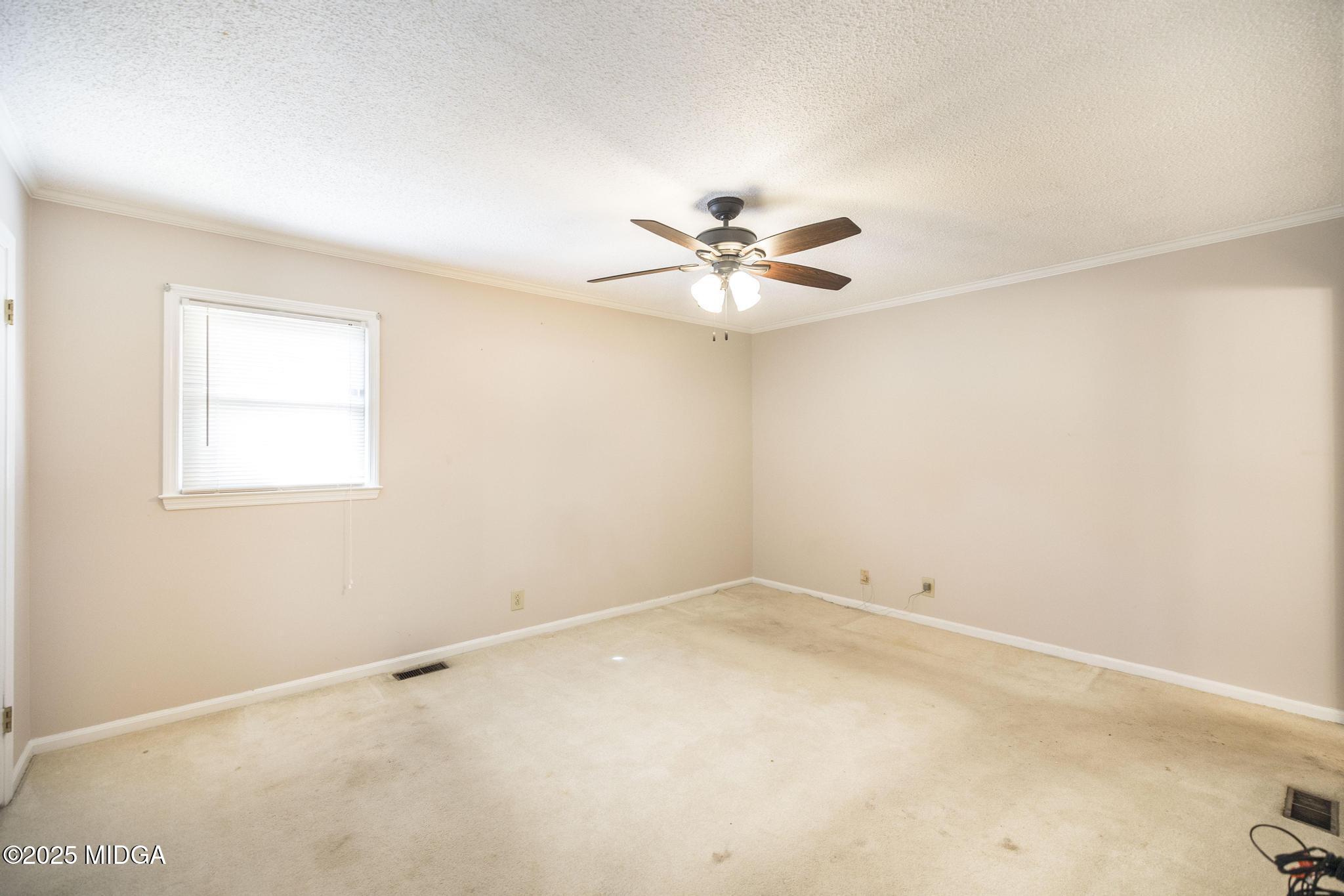 5812 Sardis Church Road Macon, GA 31216 - Photo 22 of 43 an empty room with a window and a fan