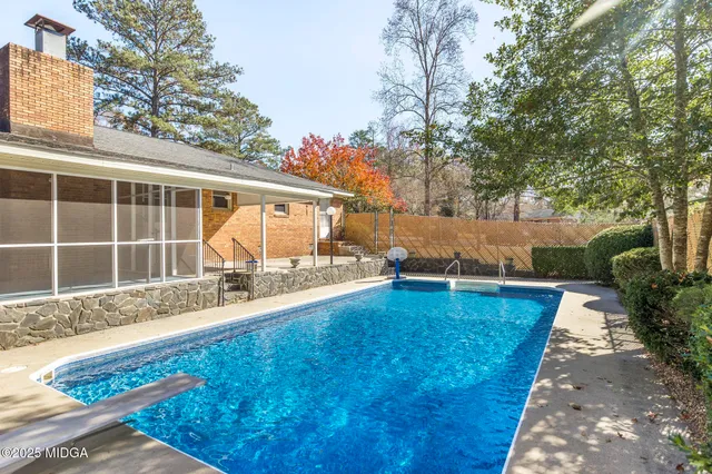 a view of a swimming pool with an outdoor seating and a forest