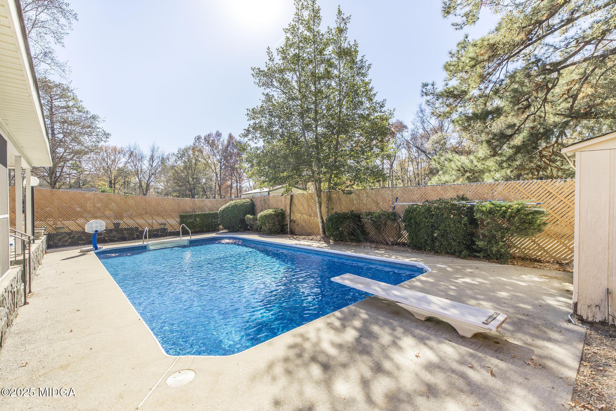 5812 Sardis Church Road Macon, GA 31216 - Photo 30 of 43 a view of a swimming pool with an outdoor seating and a forest