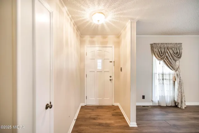 a view of a hallway with wooden floor and front door