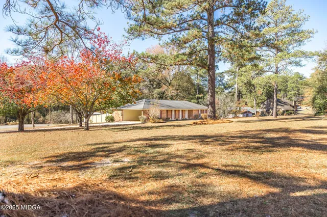 a front view of a house with a yard and trees
