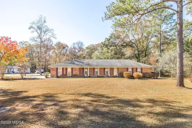 a front view of a house with a yard and trees