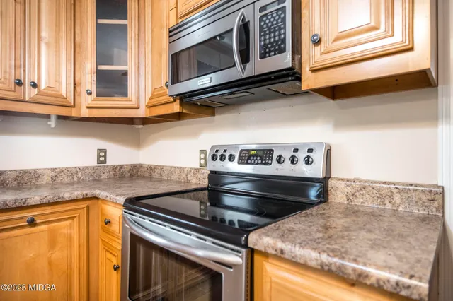 a kitchen with stainless steel appliances granite countertop a stove and a microwave