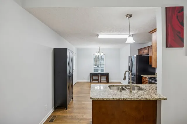 a kitchen with stainless steel appliances granite countertop a refrigerator stove and sink