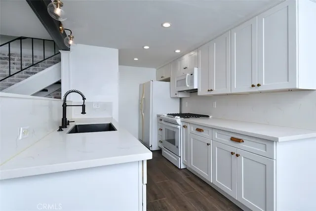 a kitchen with white cabinets stainless steel appliances and sink