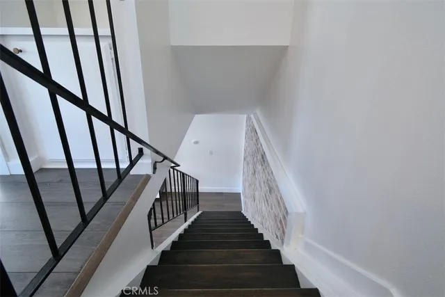a view of staircase with wooden floor and white walls