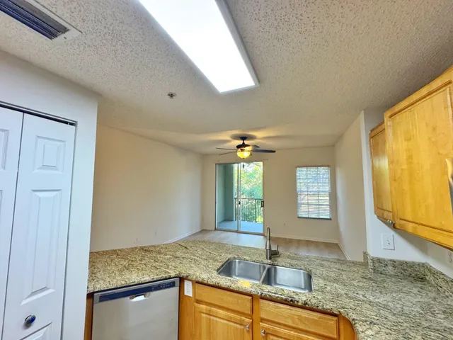 a kitchen with stainless steel appliances granite countertop a refrigerator stove and sink