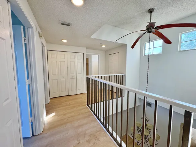 an empty room with a ceiling fan and window
