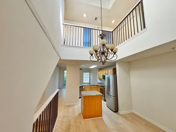 a view of a hallway with furniture and chandelier