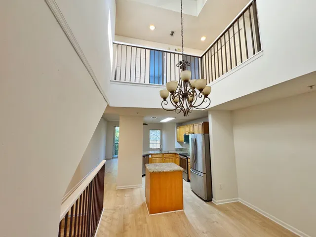 a view of a hallway with furniture and chandelier