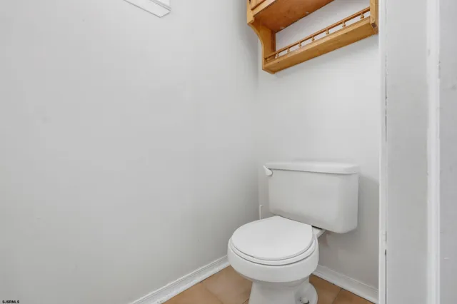 a white toilet sitting next to a white wall