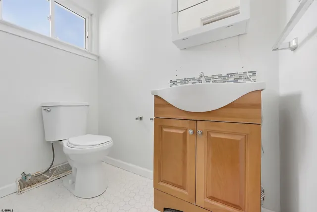 a white toilet sitting next to a white cabinets