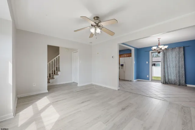 wooden floor in an empty room with a chandelier fan