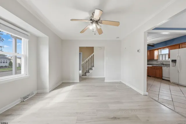 a view of an empty room with window and cabinet