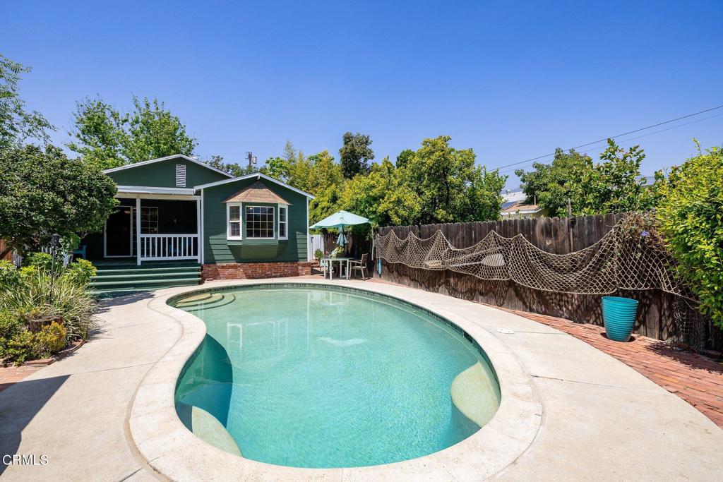 a swimming pool with outdoor seating yard and barbeque oven