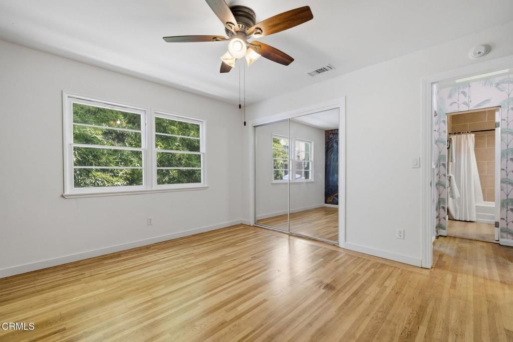 13934 Aztec Street Sylmar, CA 91342 - Photo 14 of 41 an empty room with wooden floor chandelier fan and windows