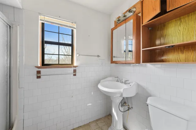a bathroom with a sink a toilet and mirror