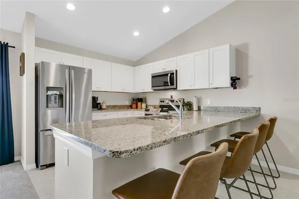 a kitchen with kitchen island a counter top space cabinets and stainless steel appliances