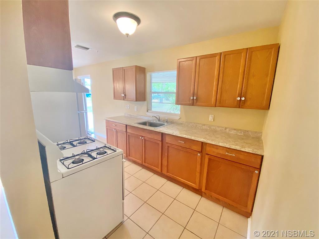 205 West Division Street DeLand, FL 32720 - Photo 5 of 15 a kitchen with granite countertop cabinets and white appliances