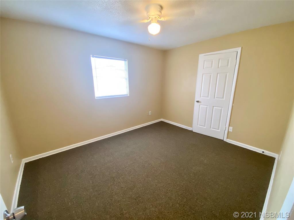 205 West Division Street DeLand, FL 32720 - Photo 8 of 15 an empty room with a chandelier fan and a window