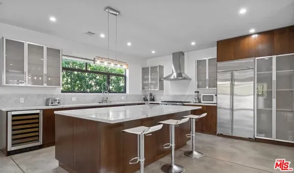 a kitchen with stainless steel appliances granite countertop a sink a stove and a refrigerator