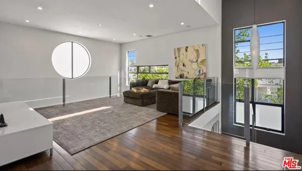 a living room with hardwood floor and a large window