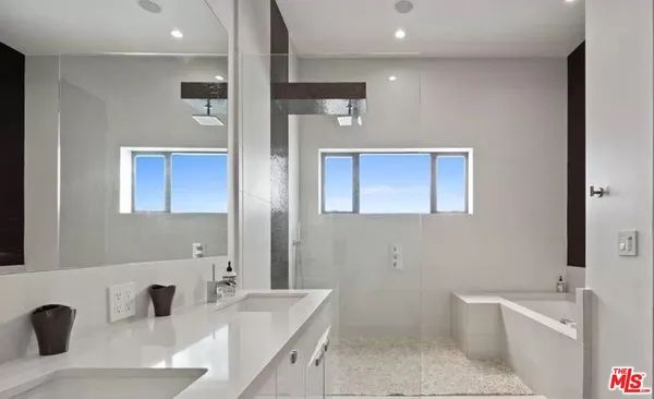 a bathroom with a tub sink and mirror
