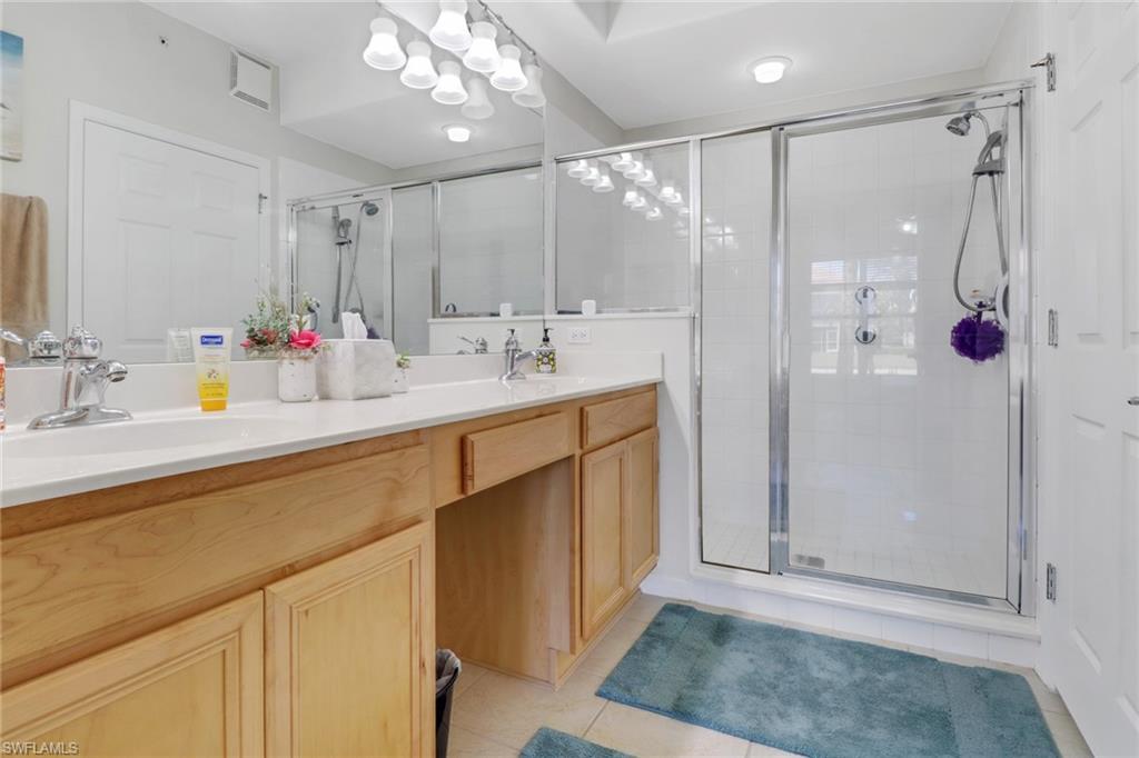 11601 Navarro Way, Unit 2102 Fort Myers, FL 33908 - Photo 14 of 25 Full bathroom featuring double vanity, light tile patterned floors, and a shower stall