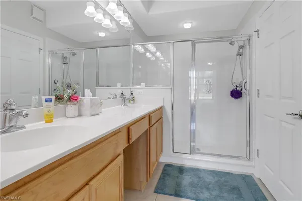 a bathroom with a shower sink vanity mirror and shower