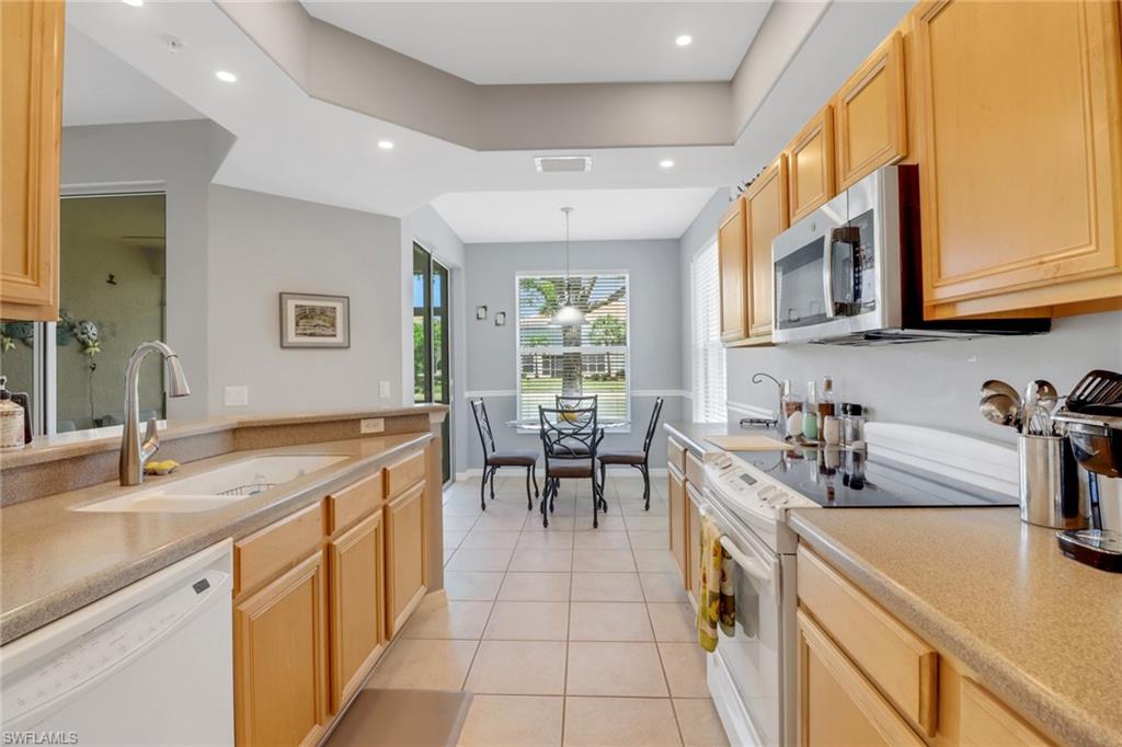 11601 Navarro Way, Unit 2102 Fort Myers, FL 33908 - Photo 5 of 25 Kitchen with white appliances, light brown cabinets, light tile patterned floors, pendant lighting, and recessed lighting