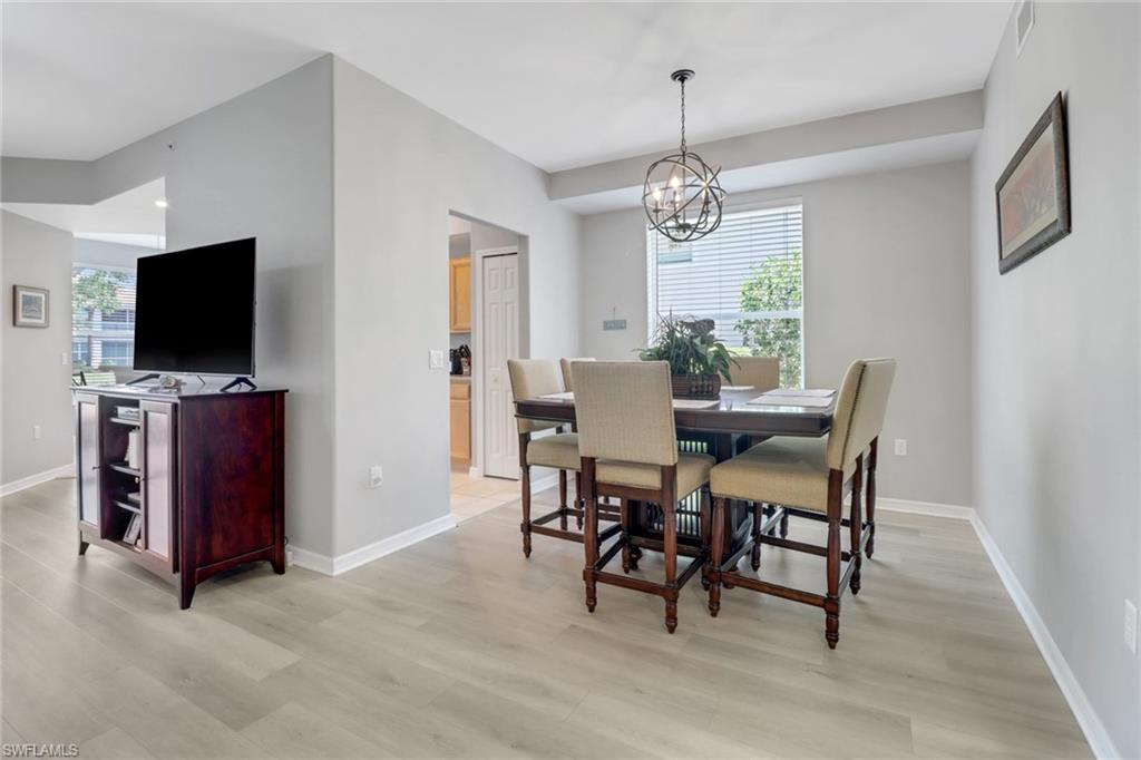 11601 Navarro Way, Unit 2102 Fort Myers, FL 33908 - Photo 6 of 25 Dining area featuring plenty of natural light, light wood-style floors, and a chandelier