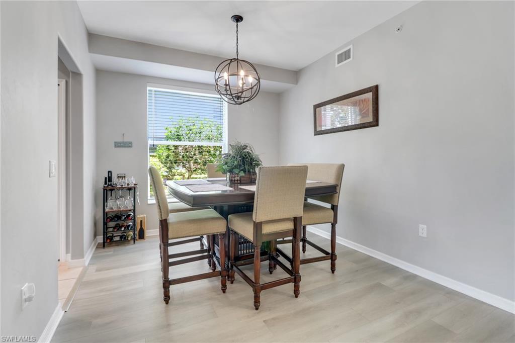 11601 Navarro Way, Unit 2102 Fort Myers, FL 33908 - Photo 7 of 25 Dining space featuring light wood-style flooring and a chandelier