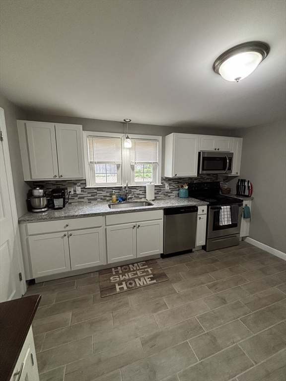 253 Gillette Avenue Springfield, MA 01118 - Photo 6 of 26 a kitchen with stainless steel appliances granite countertop a stove sink and cabinets