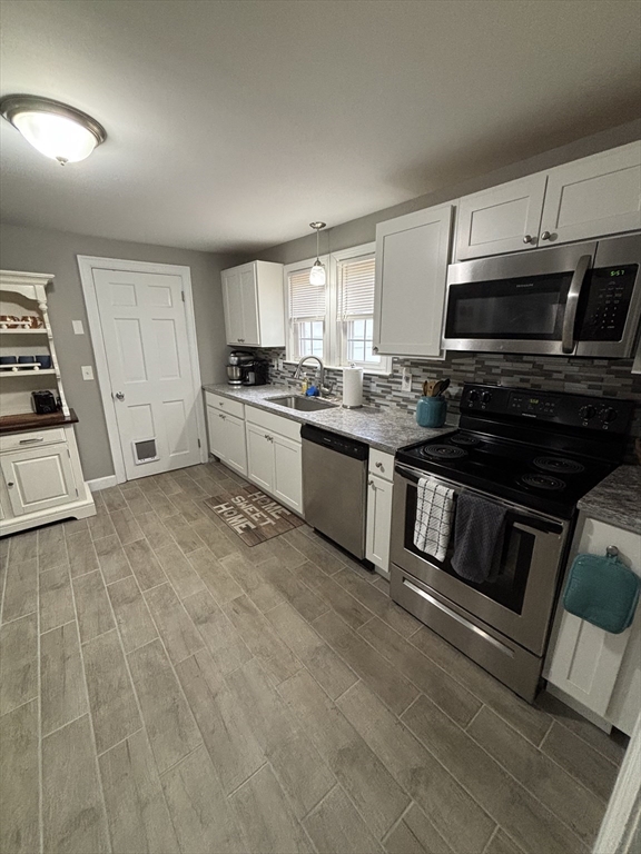 253 Gillette Avenue Springfield, MA 01118 - Photo 7 of 26 a kitchen with granite countertop a stove top oven and cabinets