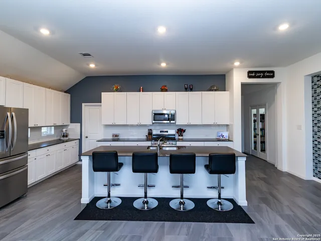 a kitchen with a sink cabinets and wooden floor