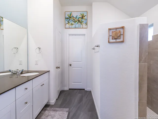 a spacious bathroom with a double vanity sink and a mirror