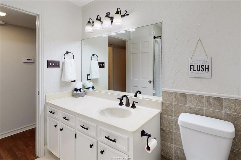 900 Westview Street Bryan, TX 77802 - Photo 17 of 30 a bathroom with a sink a toilet and a mirror
