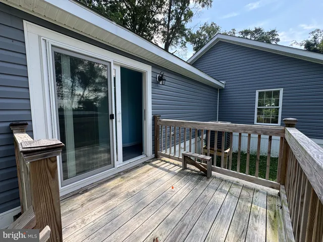 a view of a balcony with chairs and wooden floor