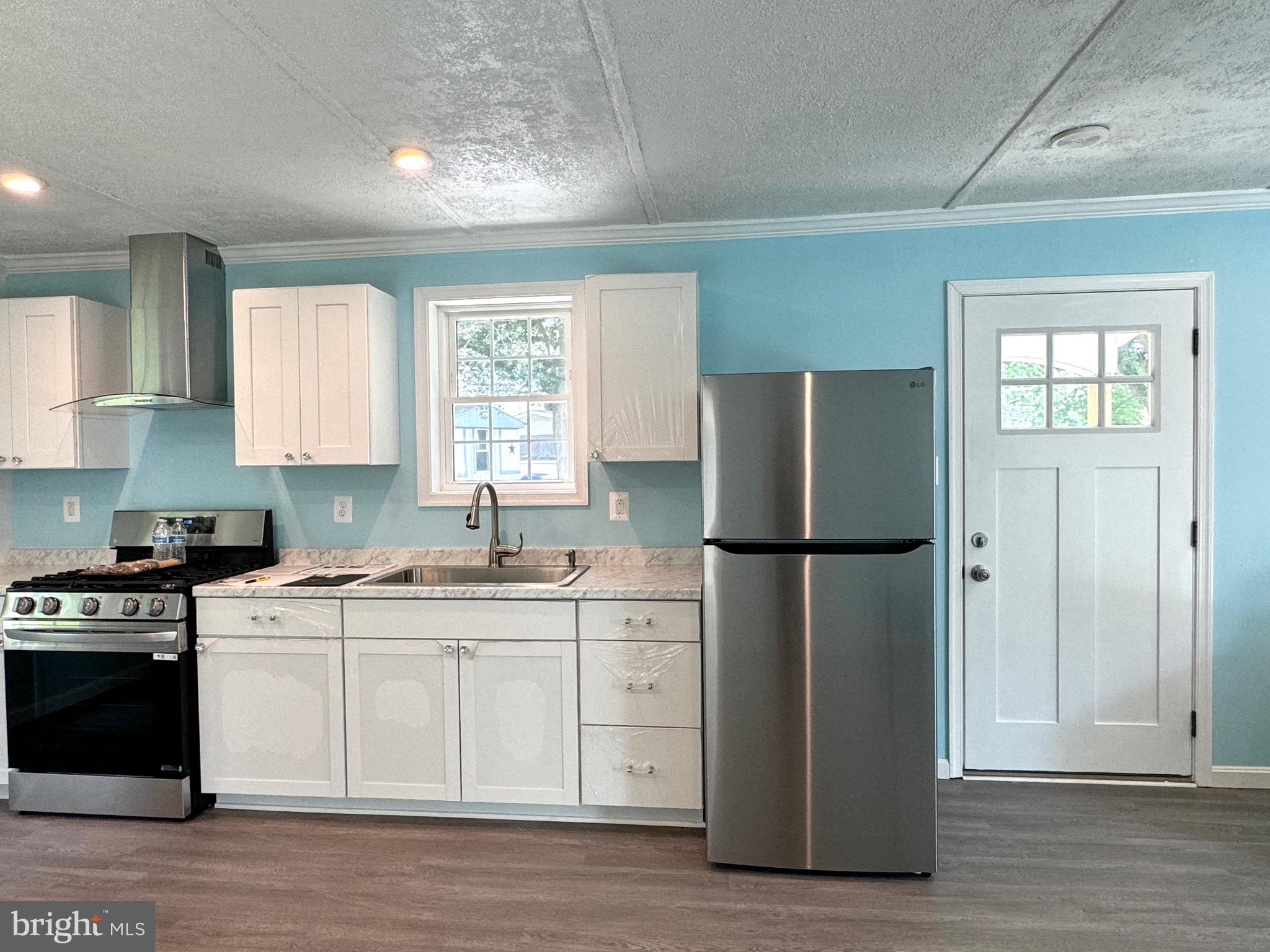 10130 Cherry Street Laurel, DE 19956 - Photo 30 of 47 a kitchen with a white cabinets and wooden floor