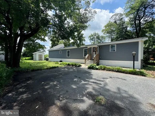 a front view of a house with yard and parking
