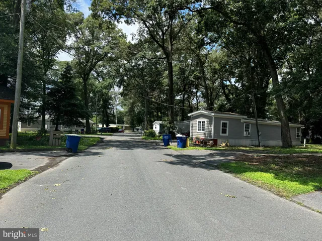 a view of street with houses and trees in the background