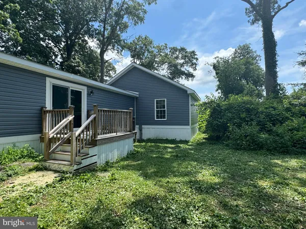 a view of a house with backyard and trees