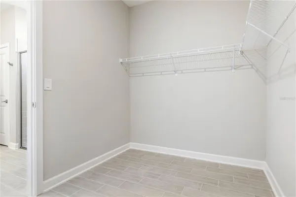 a view of an empty walk in closet with wooden floor