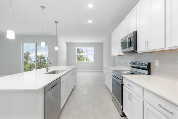 a kitchen with a sink stove and microwave