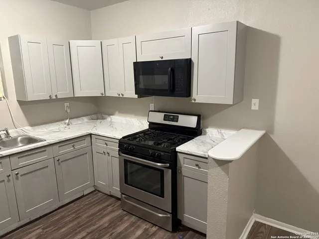 a kitchen with a sink stove and microwave