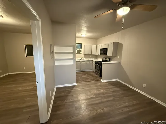 a kitchen with cabinets and wooden floor