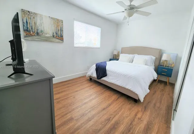 a bedroom with a bed and a flat tv screen on the dresser